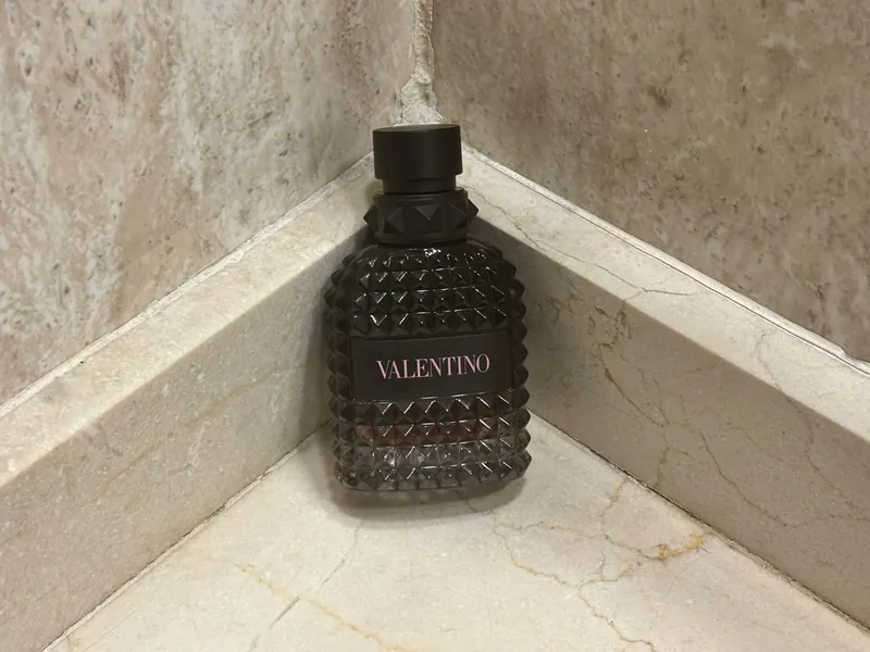 Frasco de Valentino Uomo Born in Roma Intense en una esquina de mármol